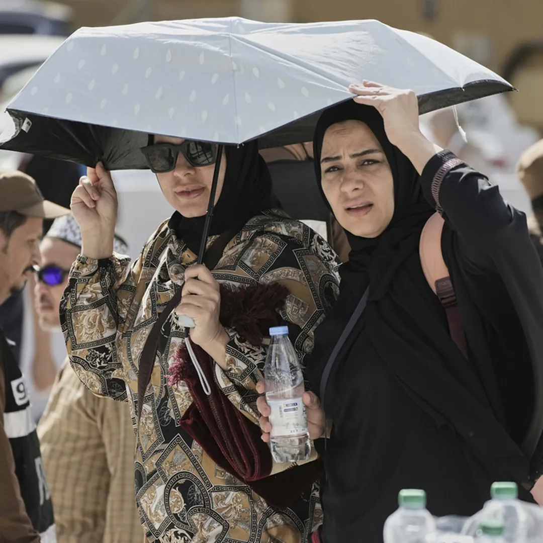 Women pilgrims under an umbrella during Hajj season